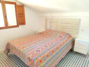 アラウリン・エル・グランデにあるLa terrazaのベッドルーム1室(カラフルなベッドカバー付)