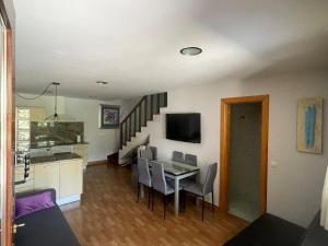 a kitchen and dining room with a table and chairs at Casa pareada rural Elechino in Entrambasaguas