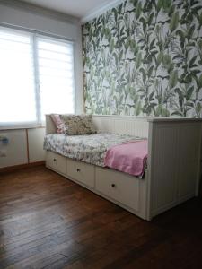 a bedroom with a bed with a floral wallpaper at Les 4 Portes in Le Mesnillard