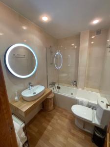 a bathroom with a sink and a toilet and a tub at Casa pareada rural Elechino in Entrambasaguas