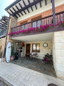 a house with a balcony with a surfboard on the side at Casa pareada rural Elechino in Entrambasaguas