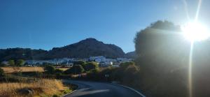 a road with the sun shining on a mountain at Casa Curro in Benaocaz