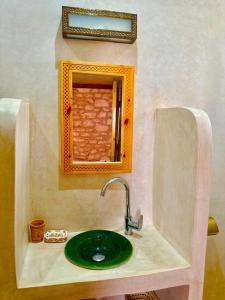 un lavabo de salle de bain avec un miroir et un vert dans l'établissement Villa Momo Kaouki, à Sidi Kaouki