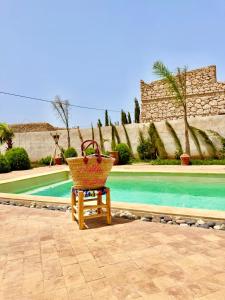 un panier posé sur une chaise à côté d'une piscine dans l'établissement Villa Momo Kaouki, à Sidi Kaouki