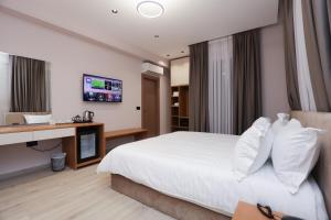a hotel room with a bed and a desk at Comfort Rezidence In Hotel in Tirana