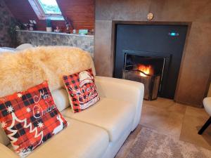 ein Wohnzimmer mit Couch und Kamin in der Unterkunft Chalé Zimbro, Serra da Estrela, Penhas da Saúde in Penhas da Saúde