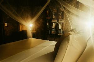 1 dormitorio con cama con cortinas y luz en Kogui Aldea, en Palomino 100 fotos más