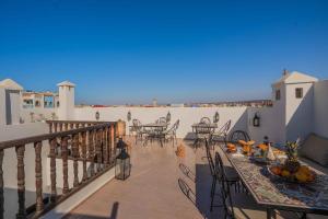 a patio with tables and chairs on a balcony at Riad Dar Irdide in Essaouira
