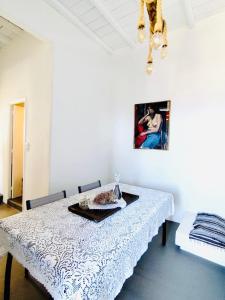 a dining room with a white table and a picture on the wall at Vista Tinos in Triandáros