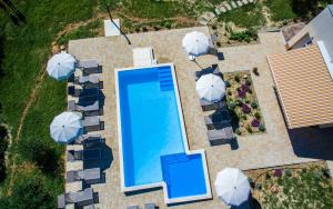 eine Draufsicht auf einen Swimmingpool mit Sonnenschirmen in der Unterkunft Apartments Lucija in Baška