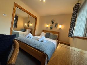 a hotel room with two beds and a mirror at No 1 High Park Lodges in Orkney