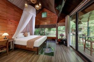 a bedroom with a bed and a desk and windows at Tam Coc Lion Kings Hotel & Resort Ninh Binh in Ninh Binh