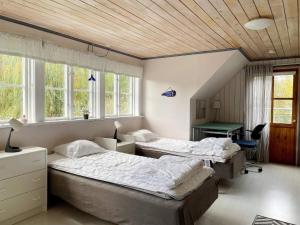 two beds in a room with windows and a desk at 4 person holiday home in Hemse in Hemse
