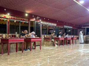 a group of people sitting at tables in a restaurant at Rayyan Bedouin life camp in Wadi Rum