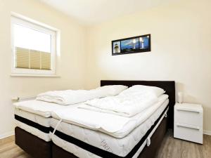 a bedroom with a large white bed with a window at 6 person holiday home in Großenbrode in Großenbrode