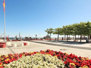 a flower bed of flowers on a sidewalk near the beach at 6 person holiday home in Großenbrode in Großenbrode