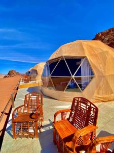 a group of chairs and tables in the desert at Katrina Rum camp in Wadi Rum