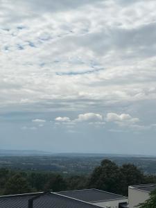 a view of a cloudy sky with trees and buildings at Cozy apartment Kosmaj Residence in Rogača +1 photo