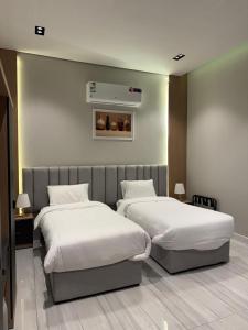 two beds in a hotel room with two at شاليهات أجواء الريف in Dammam +50 photos