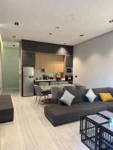 a living room with a couch and a table and a kitchen at شاليهات أجواء الريف in Dammam