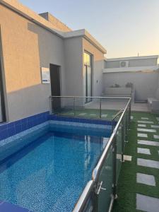 a swimming pool in front of a building at شاليهات أجواء الريف in Dammam
