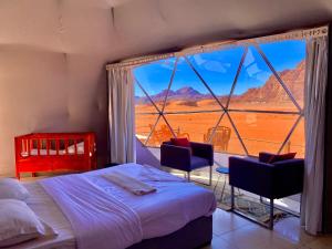 a bedroom with a bed and a large window at Katrina Rum camp in Wadi Rum