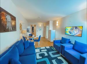 a living room with a blue couch and blue chairs at VIP ORBI city A D C in Batumi