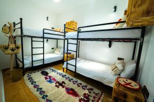 two bunk beds in a room with a rug at Mabidi Surf Taghazout in Taghazout