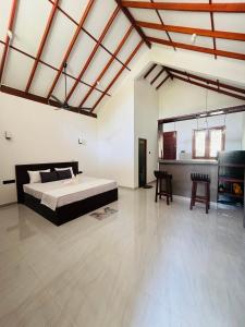 a large room with a bed and chairs in it at Rock Harmony Villa in Hikkaduwa