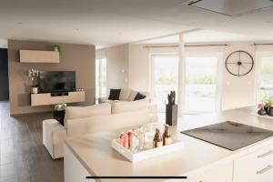 a white living room with a couch and a table at La maison du Gouty in Froid-Chapelle