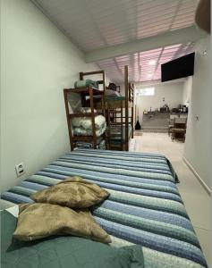 una camera da letto con un letto con cuscini sopra di Rancho do Viajante Flat APARTAMENTO A a Castro