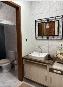 un bagno con lavandino, WC e specchio di Rancho do Viajante Flat APARTAMENTO A a Castro