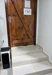 una porta di legno con delle scale davanti di Rancho do Viajante Flat APARTAMENTO A a Castro