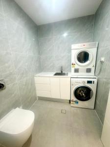 een badkamer met een wasmachine en een wastafel bij Bedroom with Ensuite Near Train Station and Airport in Revesby