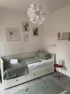 a bed in a white room with a chandelier at Strandbude Dangast in Dangast