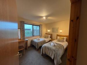 a hotel room with two beds and a window at No 2 High Park Lodges in Orkney