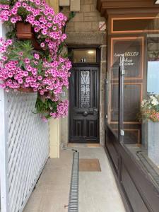 a black door with flowers on the side of a building at Cancale, vue mer, accès direct sur la baie du Mont-Saint-Michel in Cancale