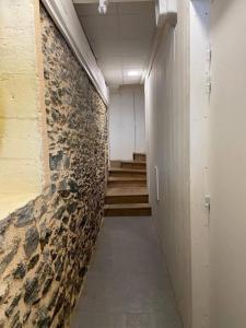 a hallway with stairs and a stone wall at Cancale, vue mer, accès direct sur la baie du Mont-Saint-Michel in Cancale