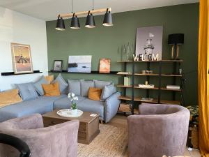 a living room with a blue couch and chairs at Cancale, vue mer, accès direct sur la baie du Mont-Saint-Michel in Cancale +29 photos