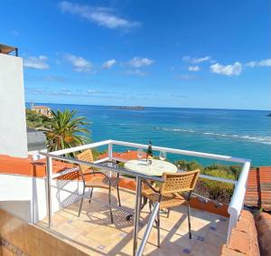 Mundaka Vista Mar L-BI-52 في مونداكا: شرفة مع طاولة وكراسي والمحيط