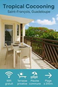 a white table and chairs on a balcony at Tropical Cocooning in Saint-François
