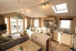 a living room with a couch and a table and a kitchen at Starlings Nest at Hamilton Lodge in Kinmel Bay +61 photos