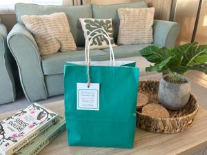 a green shopping bag on a coffee table in a living room at Starlings Nest at Hamilton Lodge in Kinmel Bay