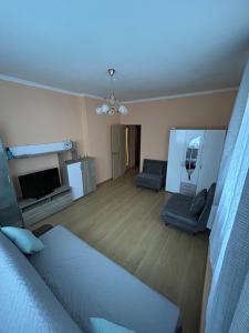 a bedroom with a bed and a living room at Ligzdina in Auce