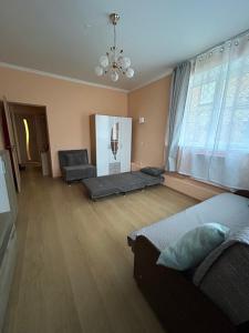 a living room with two beds and a large window at Ligzdina in Auce
