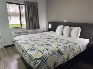 a bedroom with a large bed with a colorful comforter at Motel 6-Enfield, CT - Hartford in Enfield