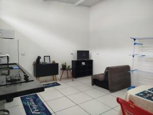 een woonkamer met een bank en een tv bij Apartamento bem localizado São Sebastião - SP in São Sebastião