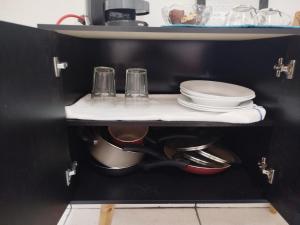 een plank met borden en keukengerei in een keuken bij Apartamento bem localizado São Sebastião - SP in São Sebastião +7 foto's