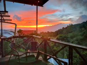una habitación con dos sillas y vistas a una puesta de sol en Roots Casa Rústica, en Valle Hornito