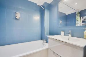 a blue bathroom with a sink and a bath tub at Les Cosy de Nancy - Le repère du roi stanislas 4étoiles in Nancy +95 photos
